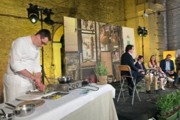 Sul palco dell'evento, chef Giacomo Sacchetto intento a preparare 